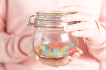 Female holding glass jar full of jelly beansの写真素材
