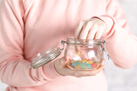 Female holding glass jar full of jelly beansの写真素材
