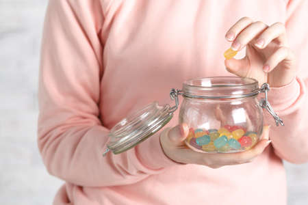 Female holding glass jar full of jelly beansの写真素材