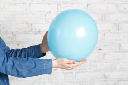 Blue balloon in female handsの写真素材