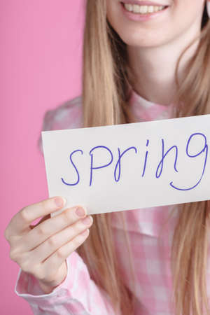 Words spring in hands of young female in pinkの写真素材