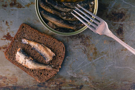 Open fish preserves and fish on the forkの写真素材