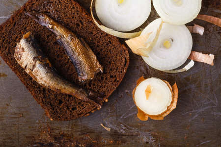 Canned sprats in tin can with rye bread. On rustic backgroundの写真素材