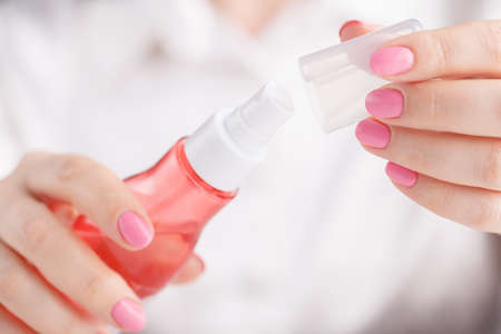 Woman`s hands spraying perfumeの写真素材