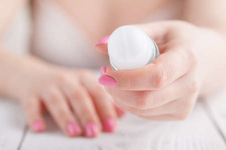 Female hand with antiperspirant bottle