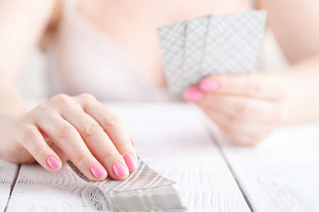 woman's hand holding playing cards on whiteの写真素材