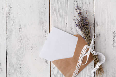 Envelope on white wooden table, flat lay, top view