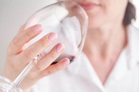 Woman holding red wine glass at restaurant
