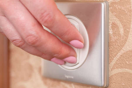 Hand turning wall light switch