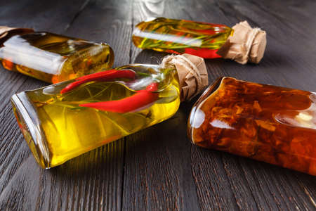 Assortment of spicy oils with herbs and spices in different bottles