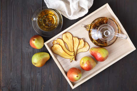 Dried pears with tea on a wooden tray, top view. Healthy breakfast. Flat layの写真素材
