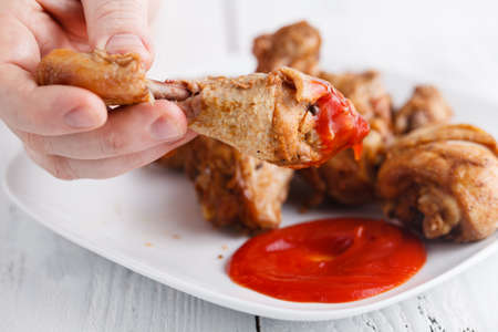 Eat unhealthy fry chicken leg with ketchupの写真素材