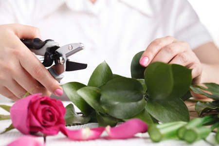 Female florist make bouqet on table^ working prosess