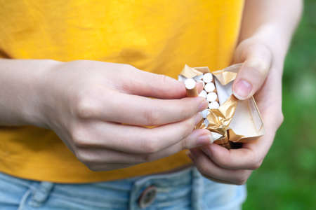 Tobacco addiction. Nicotine smoke. Girl brakes cigarette. Unhealthy, danger, bad, narcotic habit. White filter. Health risk, cancer illness. Quit, stop toxic drug. Lifestyle concept. Pack in handの写真素材