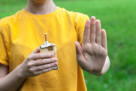 Stop smoking cigarettes concept. Portrait of beautiful smiling girl holding broken cigarette in hands. Happy female quitting smoking cigarettes. Quit bad habit, health care concept. No smoking.の写真素材