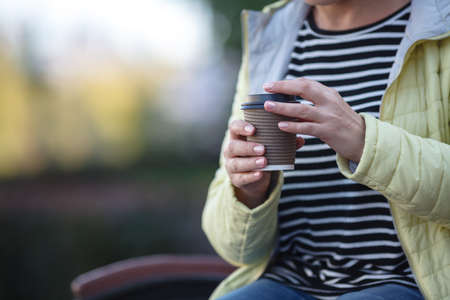 Young woman drinking coffee from disposable cupの写真素材