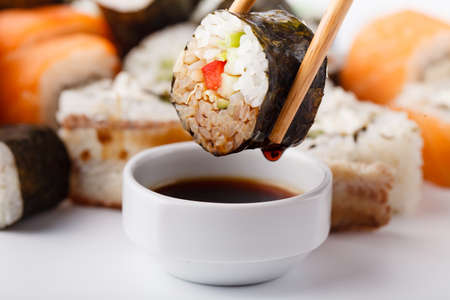 Female hand holding wooden sticks Philadelphia roll with salmonの写真素材