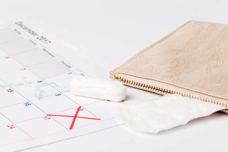 Planning pointing at date in calendar with menstrual  tampons conceptの写真素材
