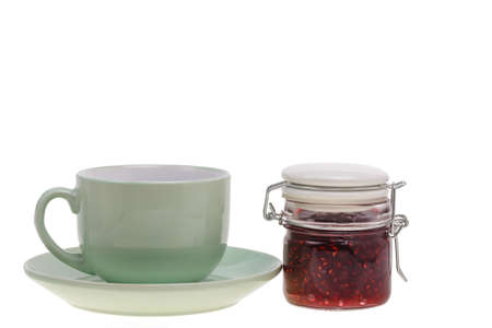 a cup and a jar of jam on whiteの写真素材