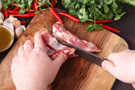 Chef Butcher cutting lamb meat with knife on kitchen, cooking proteine foodの写真素材