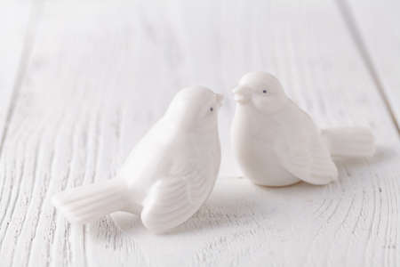 Two white ceramic birds is kissing togetherの写真素材