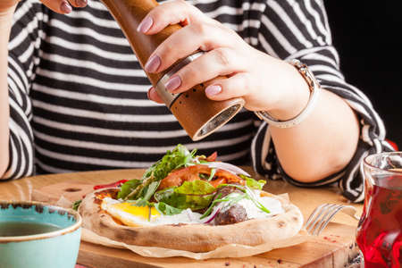 Young woman having breakfast in street cafe