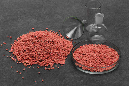 Mineral fertilizer with phosphorus in red with chemical glassの写真素材