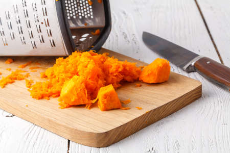 Fresh orange pumpkin, sliced and grated, prepare for cooking. Organic, seasonal, natural and healthy food conceptの写真素材