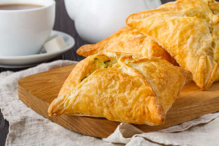 Puff pastry triangles filled with feta cheese and spinach on wooden tableの写真素材