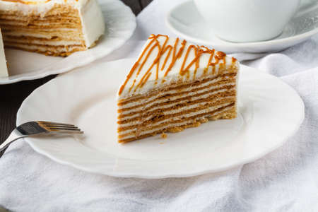 Slice of layered honey cake. Russian cake Medovik with walnutsの写真素材