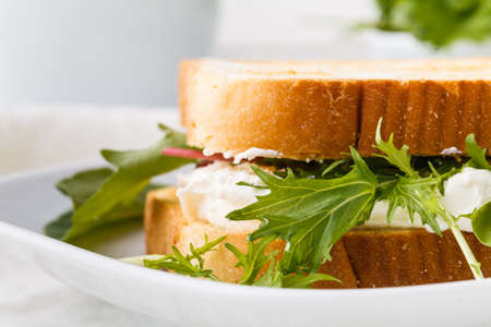Healthy toast with goats cheese, avocado, arugula and sun dried tomatoes on rustic wooden tableの写真素材