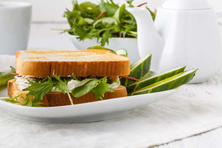 Healthy toast with goats cheese, avocado, arugula and sun dried tomatoes on rustic wooden tableの写真素材