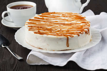 Homemade honey cake with sour cream on a wooden table with raisins and nutsの写真素材