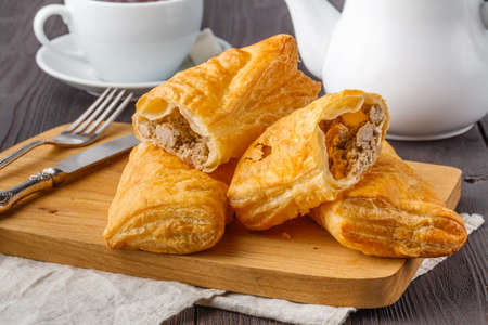 Puff pastry triangles filled with feta cheese and spinach on wooden tableの写真素材