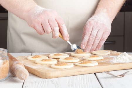 cooking and home concept - close up of hands making cookies from fresh dough at home の写真素材