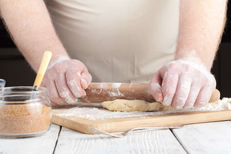 cooking and home concept - close up of hands making cookies from fresh dough at homeの写真素材