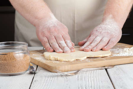 cooking and home concept - close up of hands making cookies from fresh dough at homeの写真素材