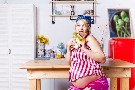 during pregnancy, a woman really wants chocolate, the model eats a large bar of chocolateの写真素材