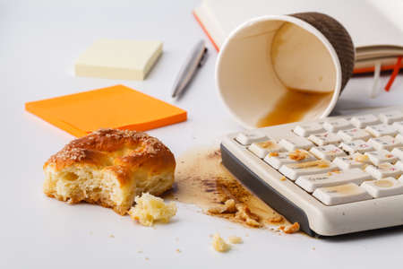 Result of eating in office, Coffee and damaged computer keyboard close upの写真素材