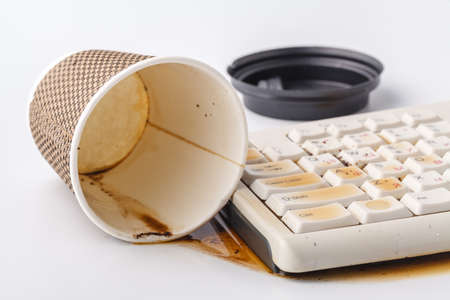 coffee spilling on keyboard ib work place officeの写真素材