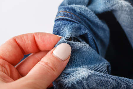 Human shows a big hole on its blue jeansの写真素材