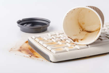 Spilled coffee on computer keyboardの写真素材