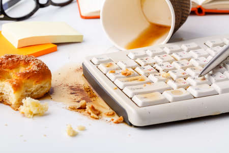 Result of eating in office, Coffee and damaged computer keyboard close upの写真素材