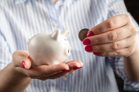 Save money concept, Piggy bank in a human hand with coin
