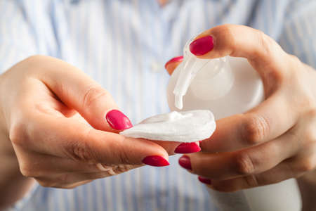 Tonic lotion for the face with a cotton pad in the hand patternの写真素材