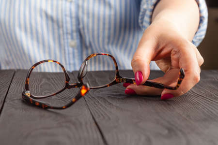Glasses frame in wonam hand on wooden table
