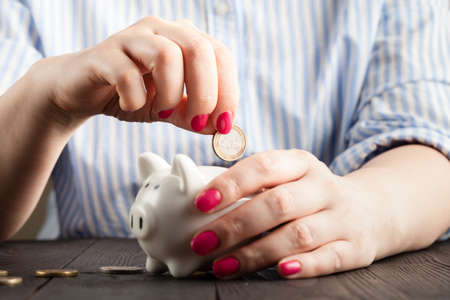 Save money concept, Piggy bank in a human hand with coinの写真素材