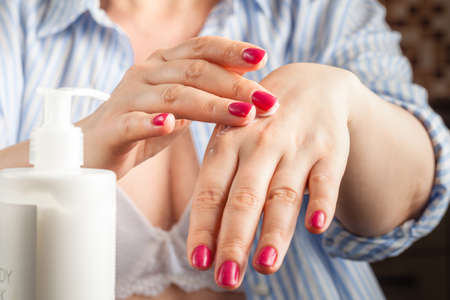 Closeup of woman hands applying creaの写真素材