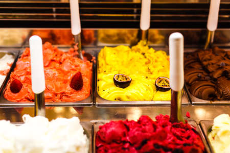 Ice cream fridge with creamy and fruit Italian ice cream steel serving counter with many of refreshing sweet scoopable flavors. Ice cream display, various flavors of gelato ice creamの写真素材