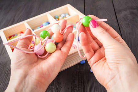 Handmade button bracelet. Set of bright colored buttons, pliers. DIY bangle jewelry idea. Easy make creative craftsの写真素材